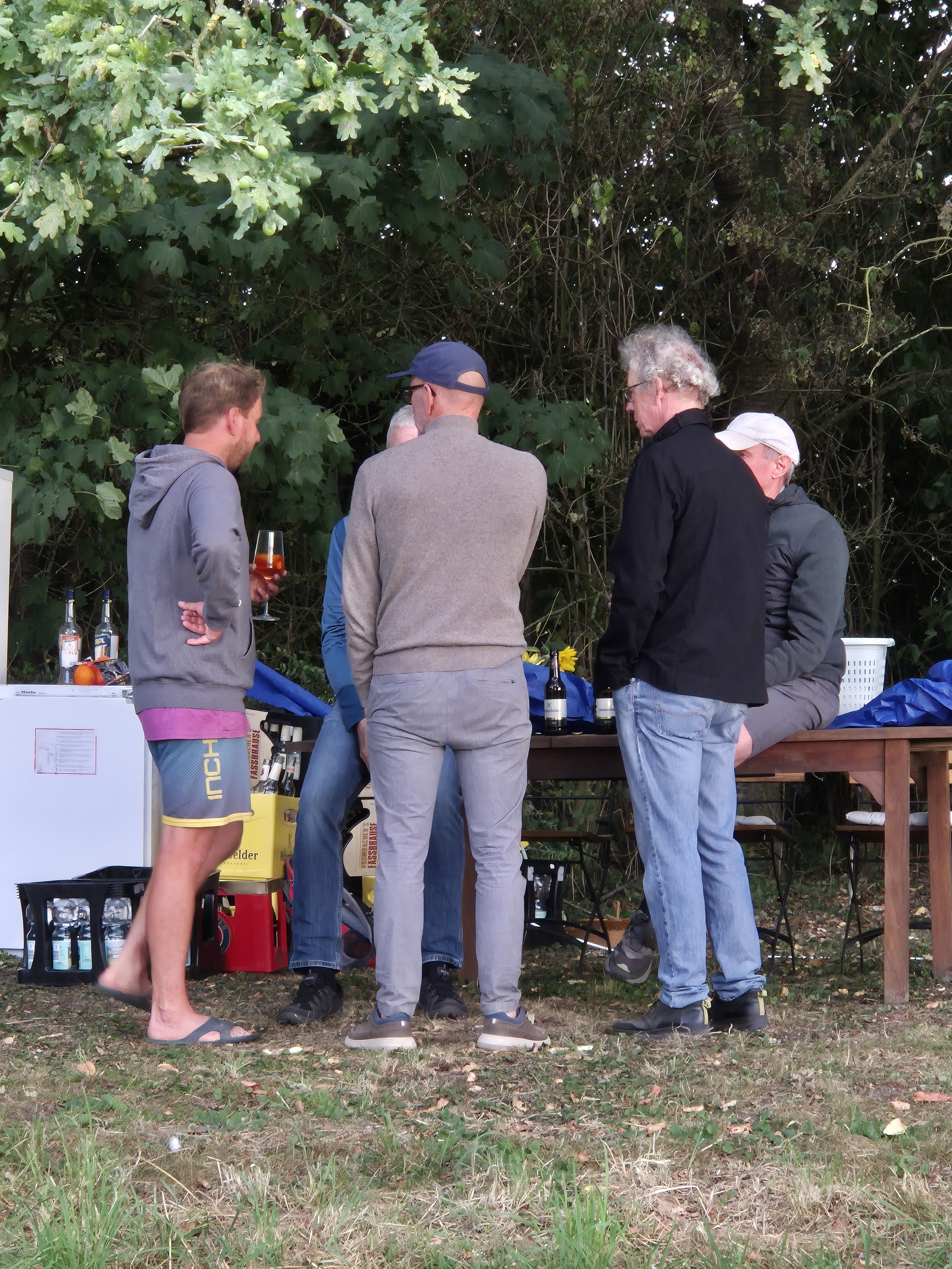 Menschen an einem Tisch im schattigen Hofbereich